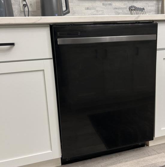 magnetic black dishwasher cover on dishwasher inserted into white kitchen cabinets white countertop