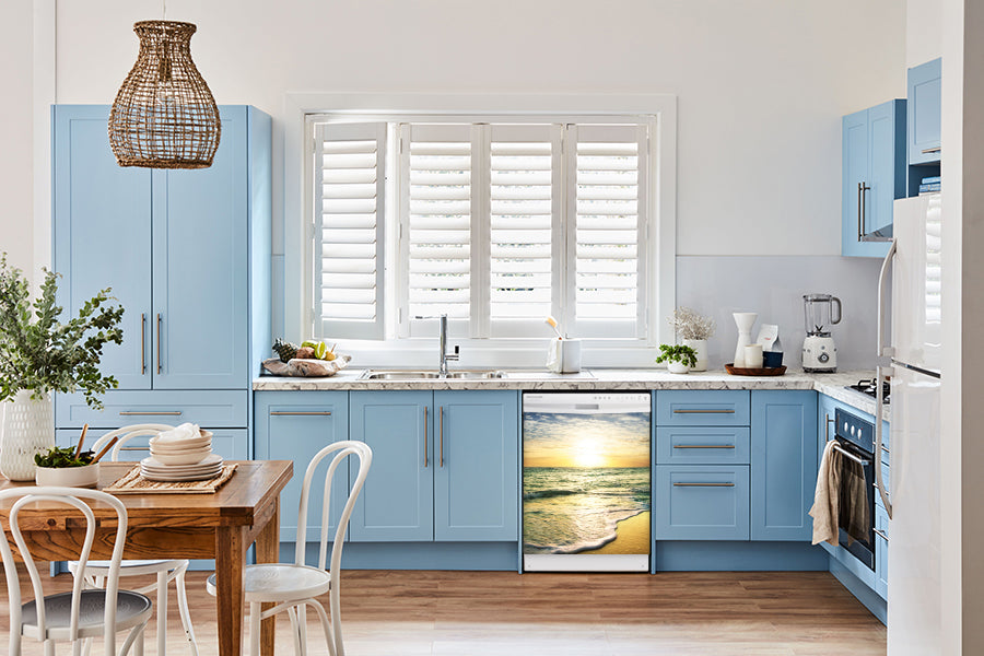  Breakfast table in kitchen with white walls, blue cabinets, marble countertop large window over sink area beach sunrise magnet skin on dishwasher white control panel 