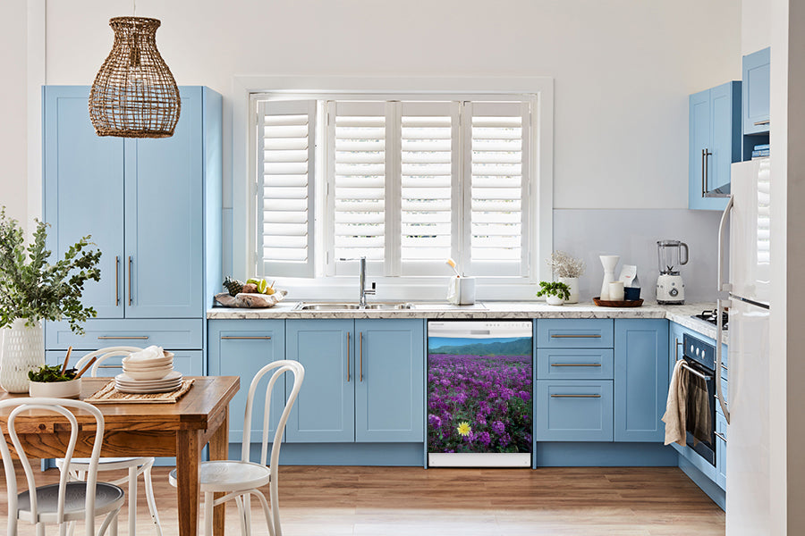 Breakfast table in kitchen with white walls, blue cabinets, marble countertop large window over sink area peek a boo yellow daisy magnet skin on dishwasher white control panel