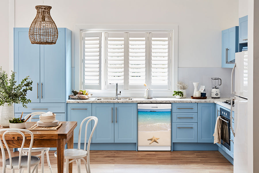 Breakfast table in kitchen with white walls, blue cabinets, marble countertop large window over sink area starfish on beach magnet skin on dishwasher white control panel