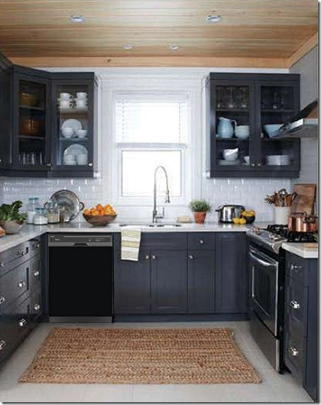 Dark Gray Kitchen Cabinets with White Marble Countertop Against White Walls Window Behind Sink Gloss Black Magnet Skin on Dishwasher Black Control Panel