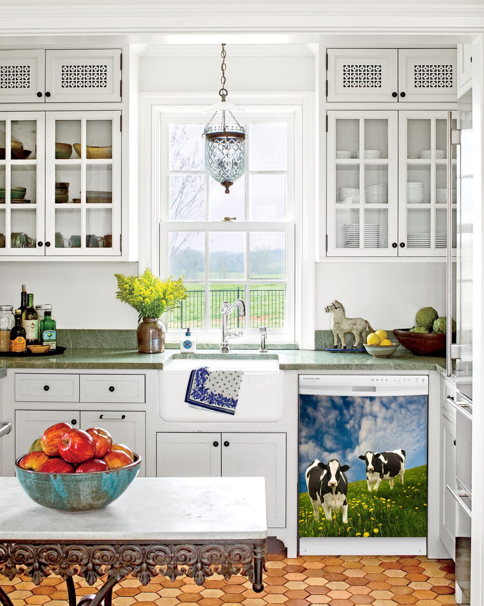 Kitchen with White Cabinets Green Countertop Terra Cotta Floor Kitchen Sink with Window next to Grazing Cows Magnet Skin on Dishwasher with White Control Panel
