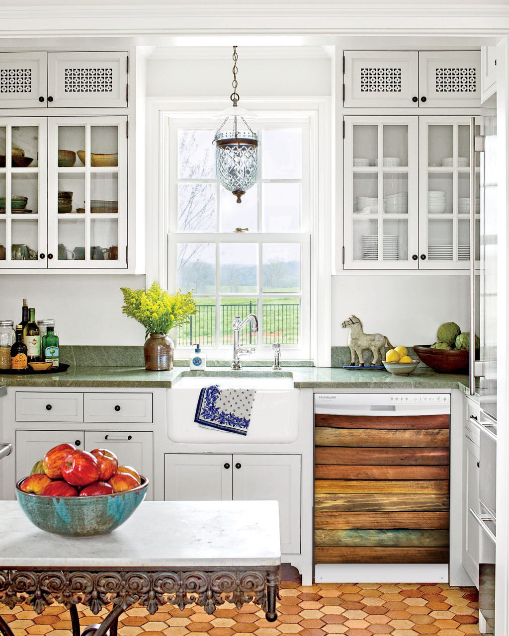 Kitchen with White Cabinets Green Countertop Terra Cotta Floor Kitchen Sink with Window next to Seasoned Wood Panel Magnet Skin on Dishwasher with White Control Panel