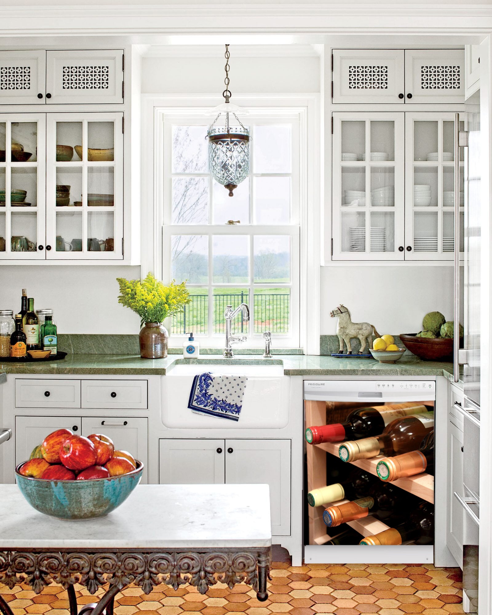 Kitchen with White Cabinets Green Countertop Terra Cotta Floor Kitchen Sink with Window next to Wine Rack Magnet Skin on Dishwasher with White Control Panel